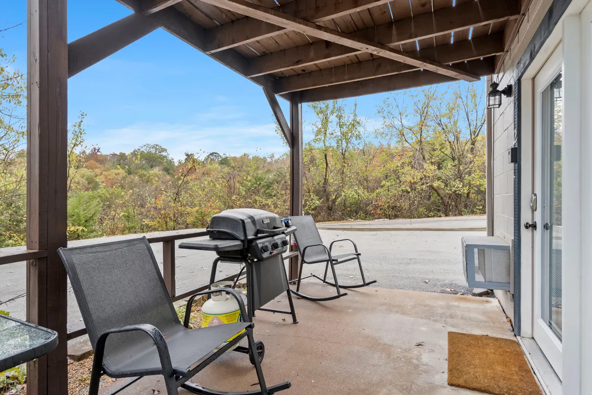 This exterior image displays a cozy outdoor space with a grill, several chairs, and open air surroundings, suggesting a comfortable and private area for relaxation or dining. The scene is casual and inviting, ideal for both quiet mornings and evening gatherings.